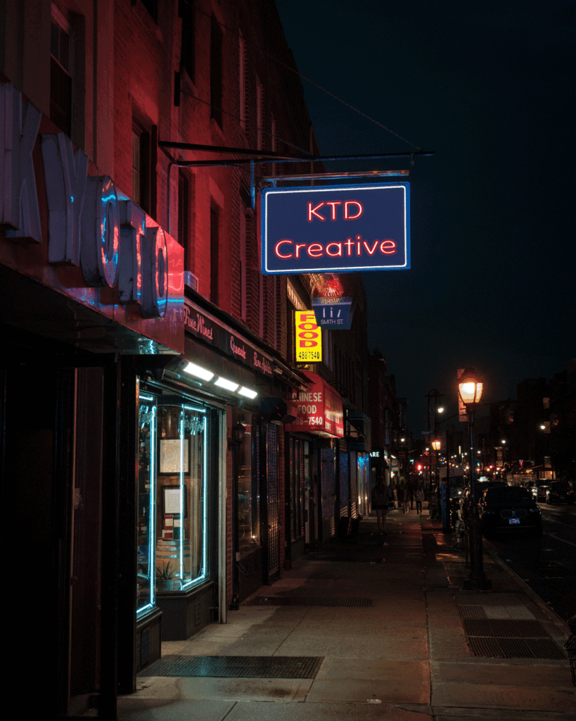 A neon KTD Creative sign in Kyoto photo at night.